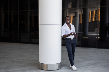 portrait of handsome african man in white shirt with mobile phone	
