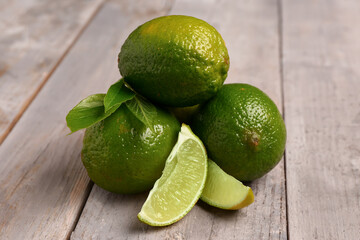 Fresh limes on grey wooden background
