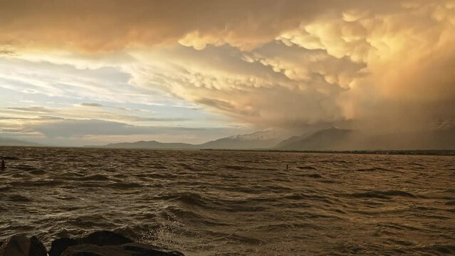 Panning view over Utah lake at sunset with storm on the horizon over Timpanogos Mountain after the rain.