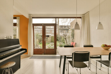 Naklejka na ściany i meble a living room with an open door and piano in the fore - image is taken from inside to outside,