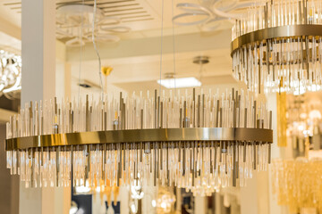 A luxury classic style chandelier is installed on the ceiling of the room. The metal frame is a...