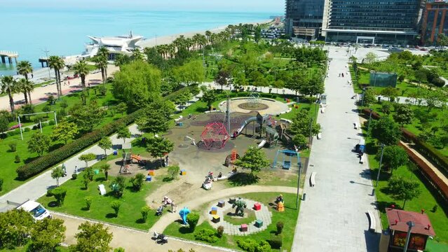 aerial photography of drones in park of Batumi Boulevard Lekha and Maria Kaczynski. This park has many facilities for children, as well as children's playground by sea on sunny day. View city Batumi