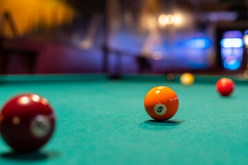 Pool (cue sports, billiards) concept image. Balls on a billiard table in a pool hall.