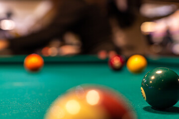 Pool (cue sports, billiards) concept image. Balls on a billiard table in a pool hall.