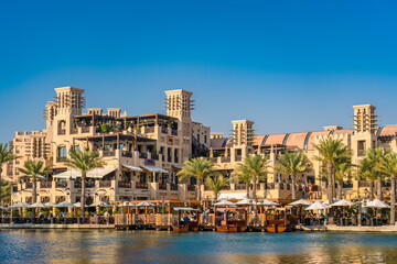 Obraz premium Impressive cityscape of Dubai, with cozy restaurants, palm trees, and azure sky.