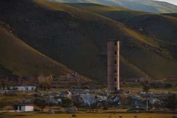 Old abandoned tower on mountains background, Kyrgyzstan