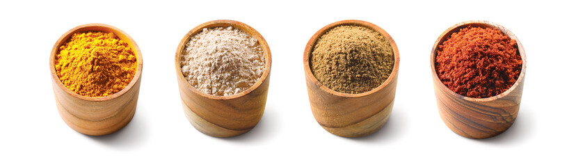 Set of powder spices in a wooden bowl isolated on white background. Wooden cup with turmeric,...