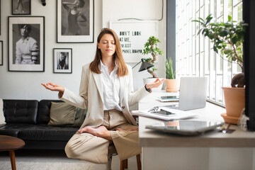 Yoga, mental health and breathing exercise. Young woman office worker meditating for stress...