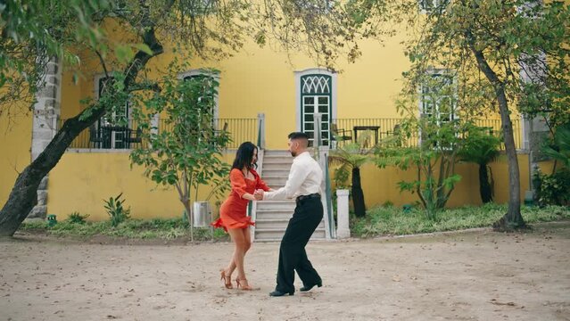 Couple samba dancers performing energetic dance on street. Pair dancing latino.