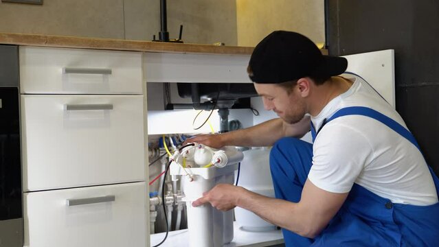 Plumber installs or change water filter. Replacement aqua filter