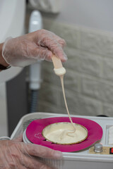Professional cosmetologist beautician preparing hot wax for sugar depilation. Sugaring procedure.
