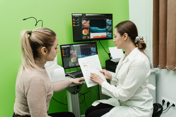 Consultation with optometrist with optical coherence tomography OCT scan to create pictures of the...