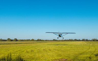 Fototapeta na wymiar Plane landing on the green field.