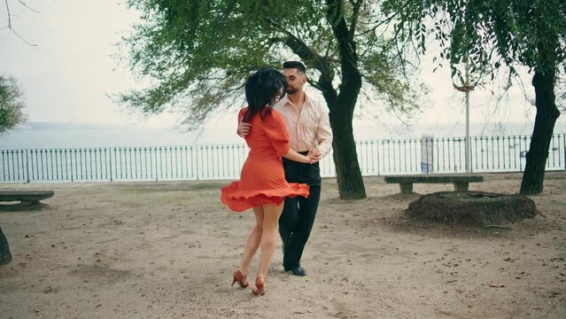 Passionate latino couple dancing on town park summer day. Pair performing salsa.