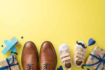 Happy Father's Day from dad and son. Top view of leather shoes, baby sneakers, mustaches, hearts, plane toy, and gift boxes on yellow background with empty space for message