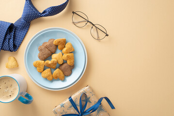 Give Dad the perfect Father's Day surprise! Top view of tasty homemade cookies, a frothy cup of delight, necktie, glasses, and giftbox on beige background. Use empty space to add your own text or ad