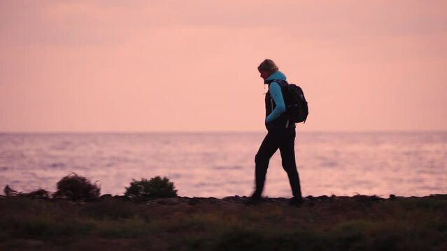 Female solo hiker walking desert ocean coastal path 