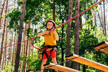 a boy runs a track in a rope park. extreme. height.