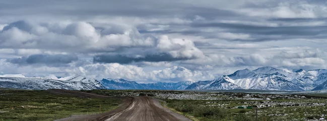 Outdoor kussens Panoramic image of Fresh July snowfall dotting the tundra and the mountains just outside the Gates of the Arctic National Park in Alaska on the Dalton Highway near Nuiqsut Alaska © Jorge Moro