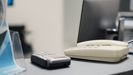Empty front desk with landline phone used to register medical appointments, registration forms and...
