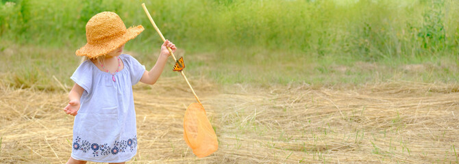child 3 years old, girl in straw hat with entomological insect net catches butterflies and...