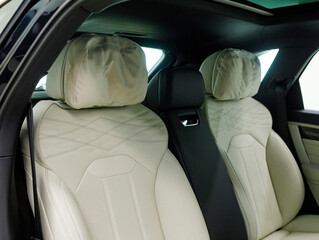 Luxury car inside. Interior of prestige modern car. Comfortable leather seats. White perforarated...