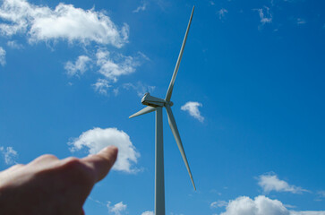 Person pointing at a windmill