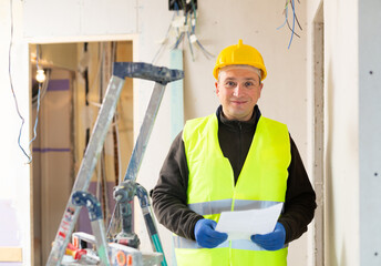 Confident builder handyman examining room and planning construction works