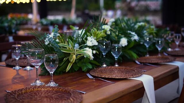 Una Mesa de Eventos que Refleja la Excelencia con flores, copas y platoa