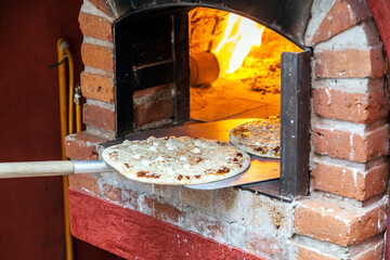 Placing pizza in the oven