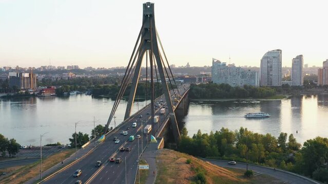 The bridge over the city river in the evening or morning. View from the drone slowly getting down.