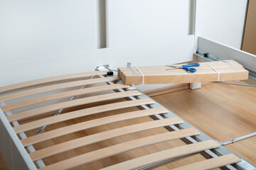 The furniture assembler assembles the bed frame, do it yourself and assemble new furniture.