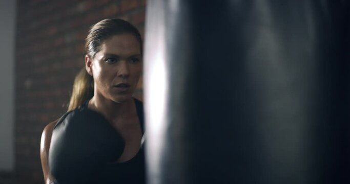 Fitness, boxer or sports woman boxing in training, exercise or workout in gym with wellness or motivation. Punching bag, strong warrior mindset or healthy girl with speed, fast or powerful punch