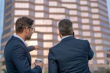 Colleagues in suit talking outdoor. Mature businessman discuss information with colleague outdoor. Two business colleagues at meeting in american New York city. Successful project.