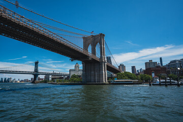 Fototapeta na wymiar Brooklyn Bridge with Manhattan Bridge to the left and Bridge Park to the right. 