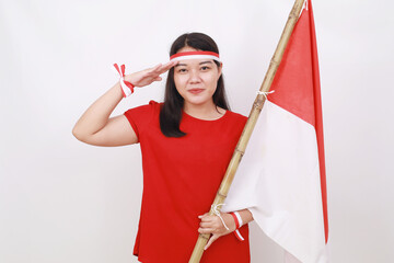 Young indonesian girl celebrate independence day while holding red white flag with respect gesture