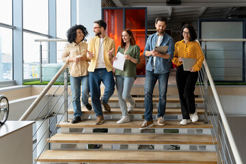 Group of successful office employees going down the stairs for a coffee break. People. Career growth
