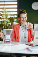 Portrait of happy business owner woman in green office