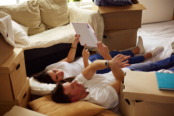 Young couple lying on the floor after unpacking boxes in their new house