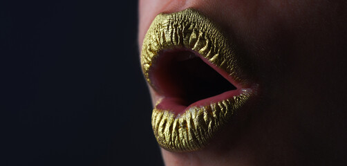 Lip with golden glitter effect. Woman mouth close up. Golden lipstick. Glamour luxury gold mouth. Gold paint on lips. Golden lips on woman mouth. Metallic body. Gold concept.