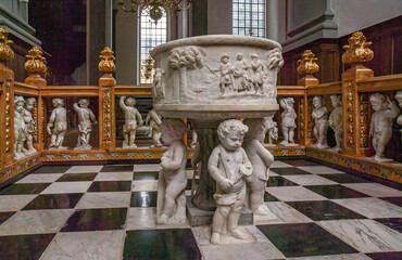Copenhagen, Denmark - September 14, 2010: Closeup of baroque sculpted marble baptismal font with...