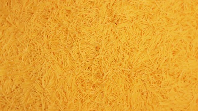Background of Uncooked Golden Noodles that Rotating Clockwise - Top View. Texture of Dry Vermicelli Turning Around. Raw Pasta - Right Rotation