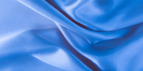 Abstract blue silk fabric texture background. Creases of satin	
