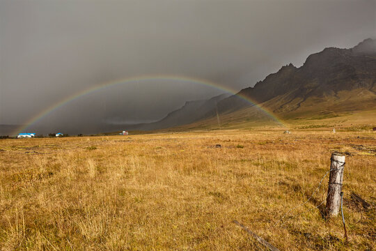 A rainbow arcs across countryside near the town of Stykkisholmur, Snaefellsnes peninsula, west coast of Iceland, Polar Regions