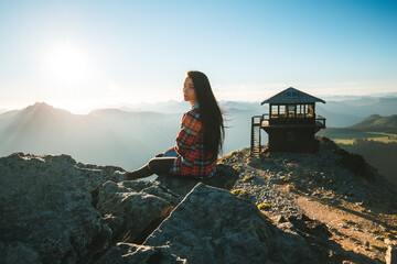 Girl sitting on the top of Mount Fremont with Mount Fremont fire lookout on the background in Mount Rainier National Park - Powered by Adobe