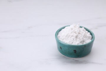 Bowl of natural starch on white marble table. Space for text