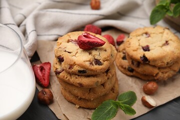 Cookies with freeze dried fruits, mint, milk and nuts on grey table, closeup