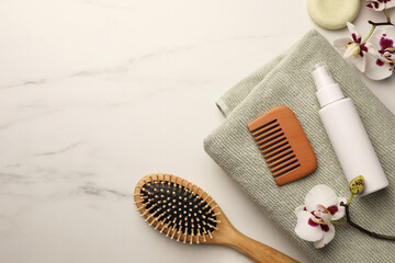 Flat lay composition with wooden hair brush and comb on white marble table, space for text - obrazy, fototapety, plakaty