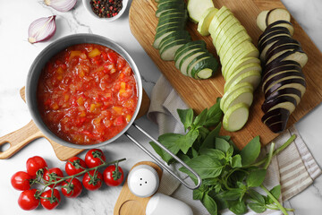 Dressing for ratatouille and different fresh cut vegetables on white marble table, flat lay