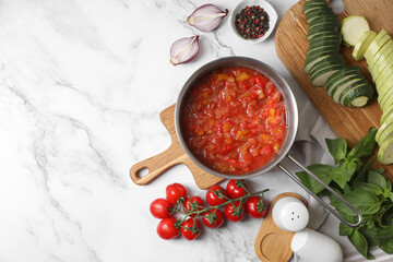 Dressing for ratatouille and different fresh vegetables on white marble table, flat lay. Space for...